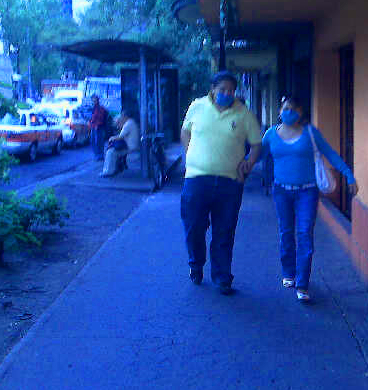 COVER YOUR MOUTH:   A couple walks down a block in the Roma neighborhood of Mexico City.  There was high demand for surgical masks in the wake of a a deadly strain of swine flu that's infected over 1,000 people. 
